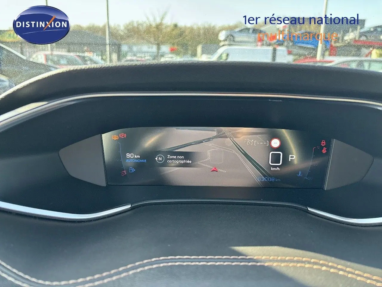 Tableau de bord numérique de Peugeot 308 blanc nacré 2021, affichant la navigation et l'autonomie restante.