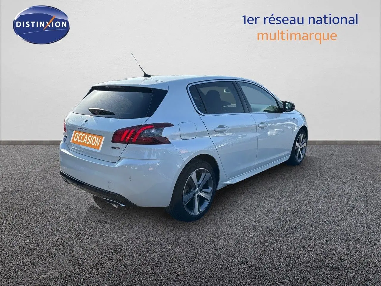 Peugeot 308 blanc nacré vue 3/4 arrière droit, avec feux arrière LED et jantes alliage 17 pouces.