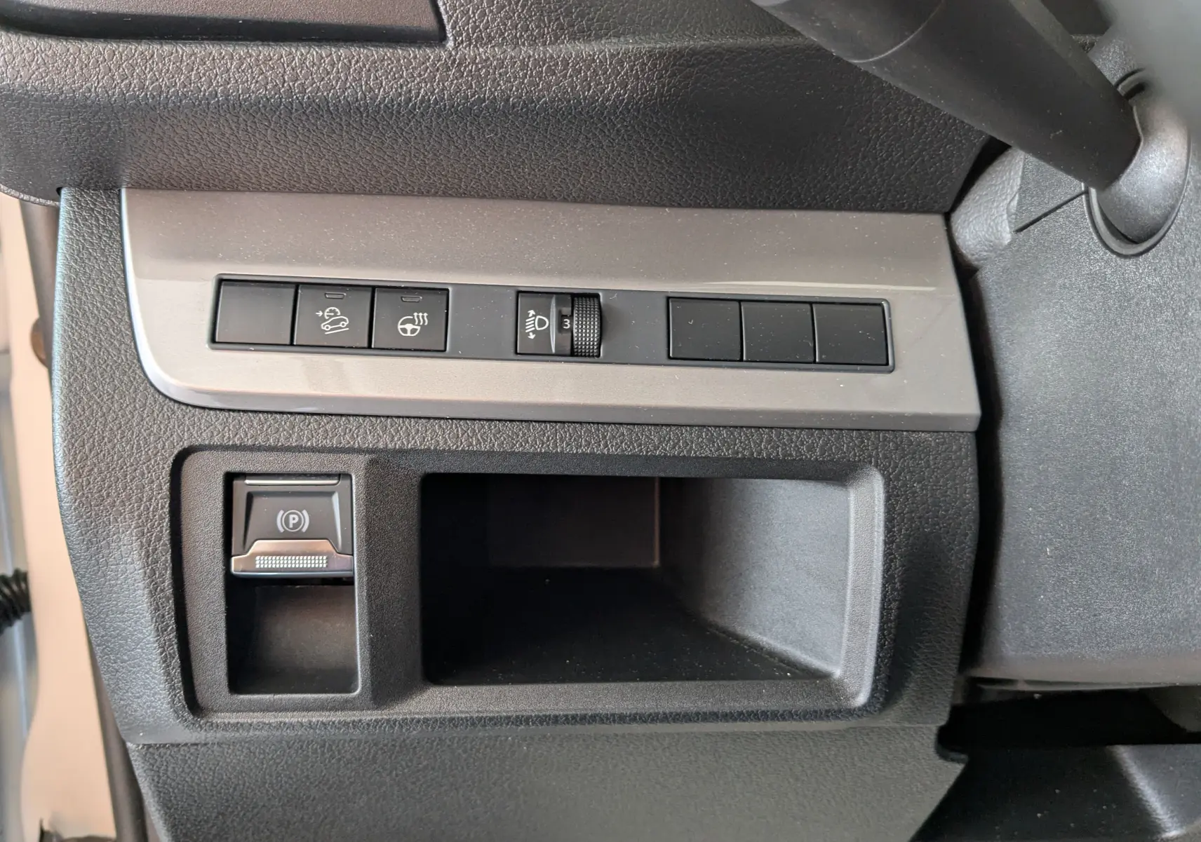 Vue rapprochée des commandes latérales noires et grises du tableau de bord du Peugeot Expert Fourgon blanc 2024.