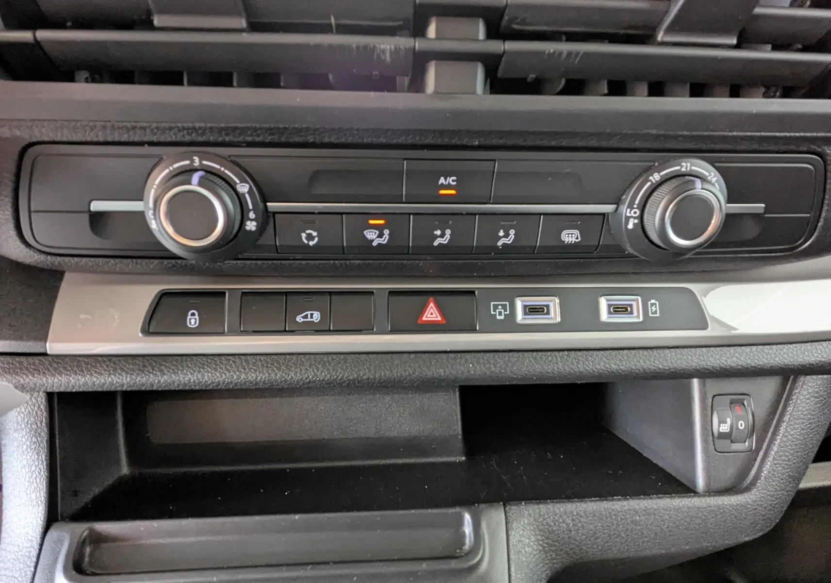 Vue rapprochée de la console centrale du Peugeot Expert Fourgon blanc 2024, avec commandes climatisation et ports USB.