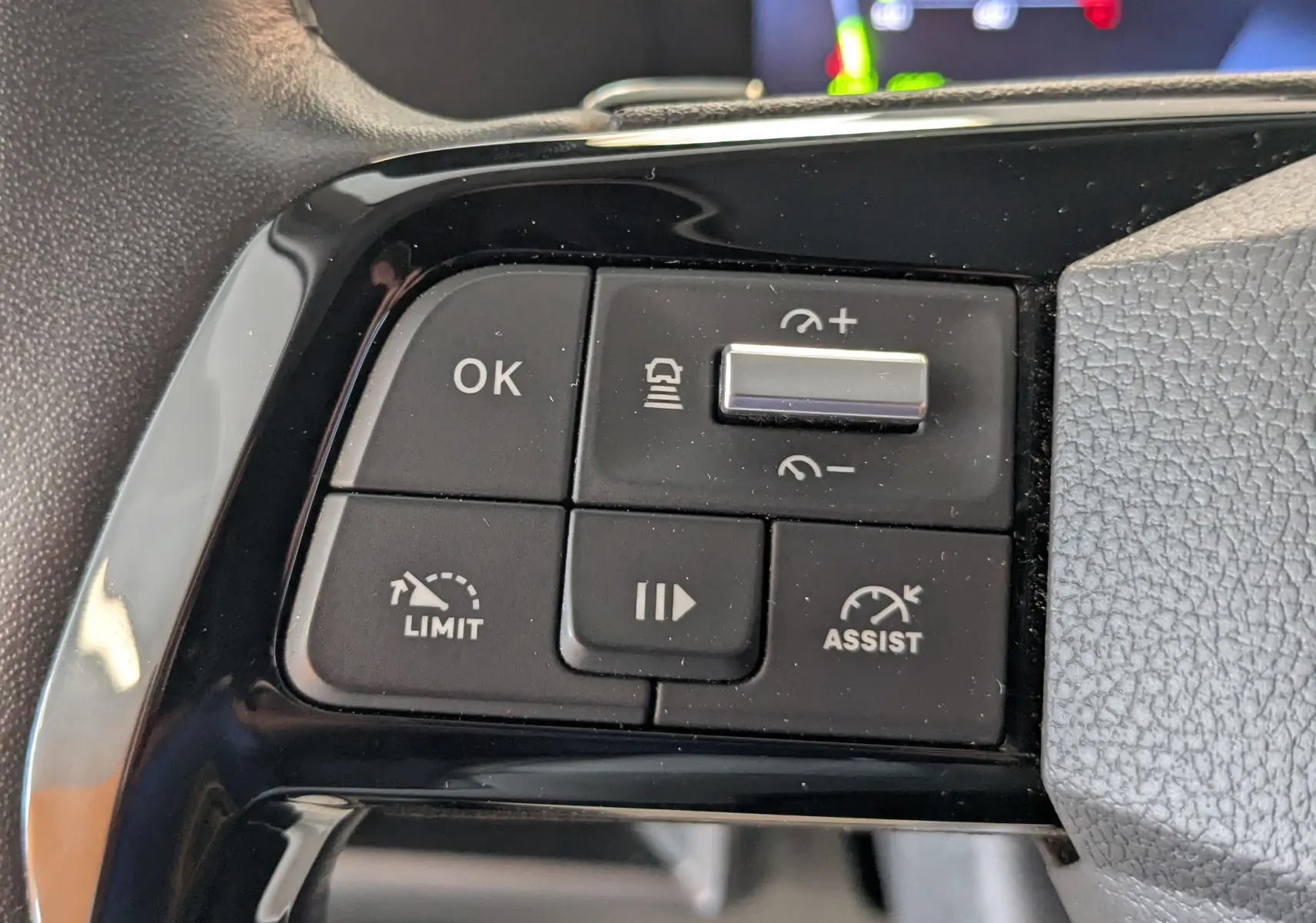 Gros plan sur les commandes de régulateur et limiteur de vitesse sur le volant du Peugeot Expert Fourgon blanc.