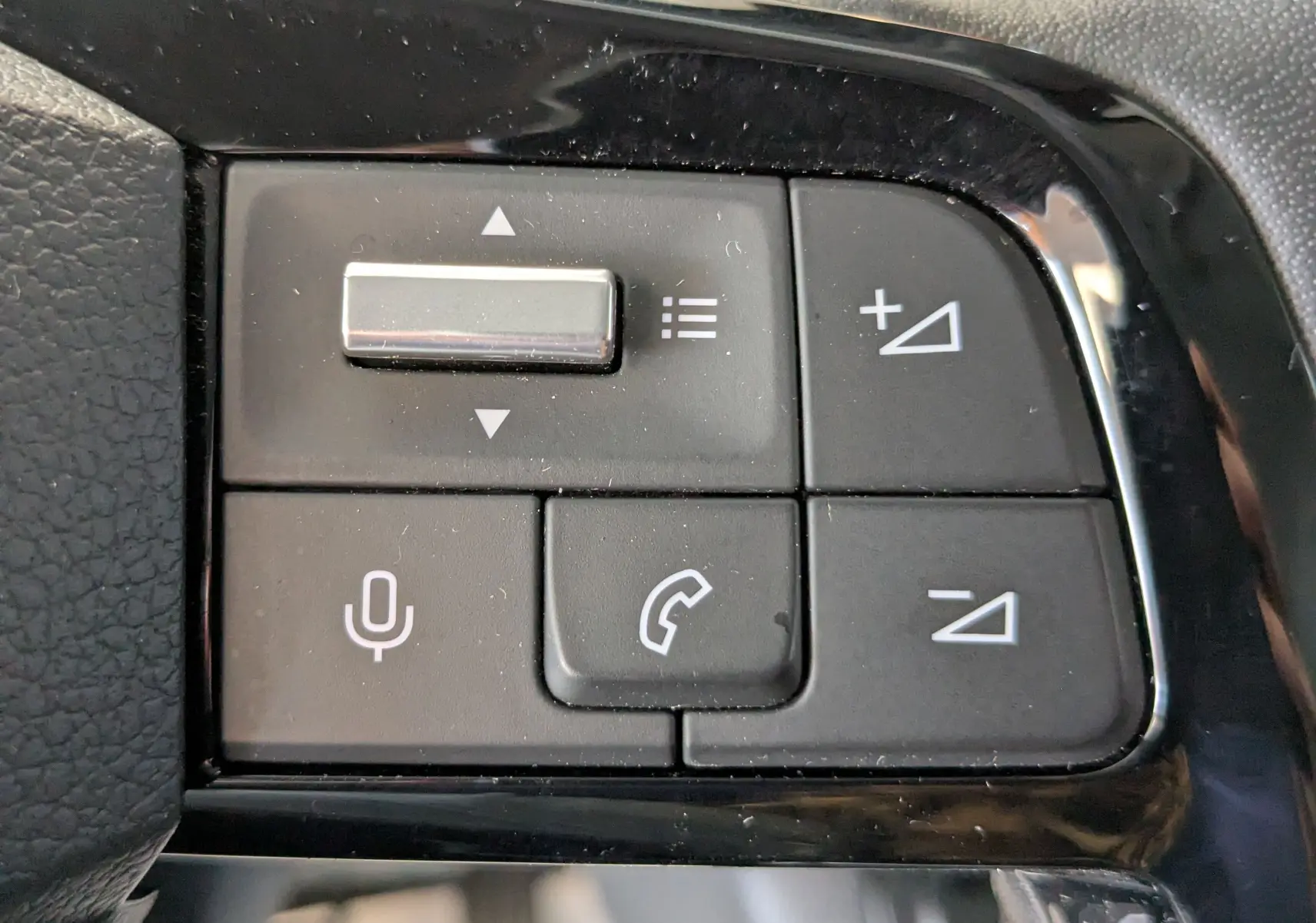 Gros plan sur les commandes noires du volant du Peugeot Expert Fourgon blanc, boutons de volume et appel téléphonique.