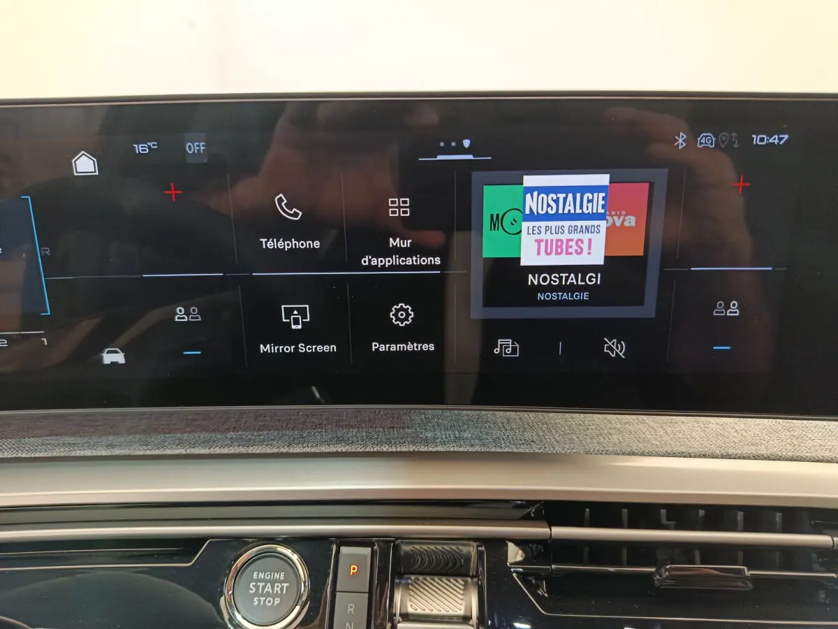 Écran tactile central affichant radio Nostalgie et commandes multimédia dans le tableau de bord du Peugeot 3008 gris clair.