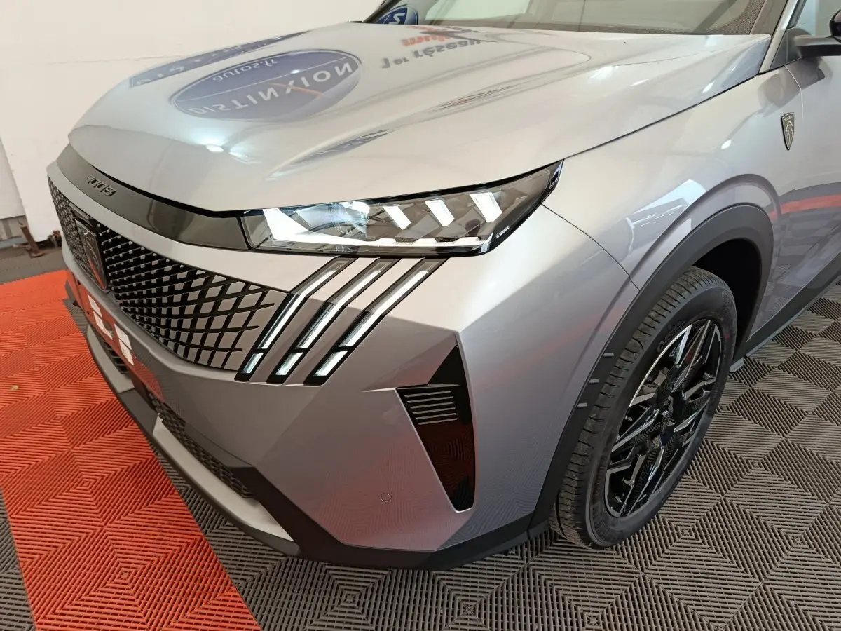 Vue 3/4 avant droit du Peugeot 3008 gris clair avec phares LED et signature lumineuse distinctive en griffes.