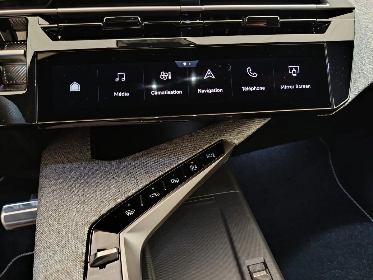 Vue rapprochée de la console centrale du Peugeot 3008 gris clair 2025, avec écran tactile et commandes climatisation intégrées.