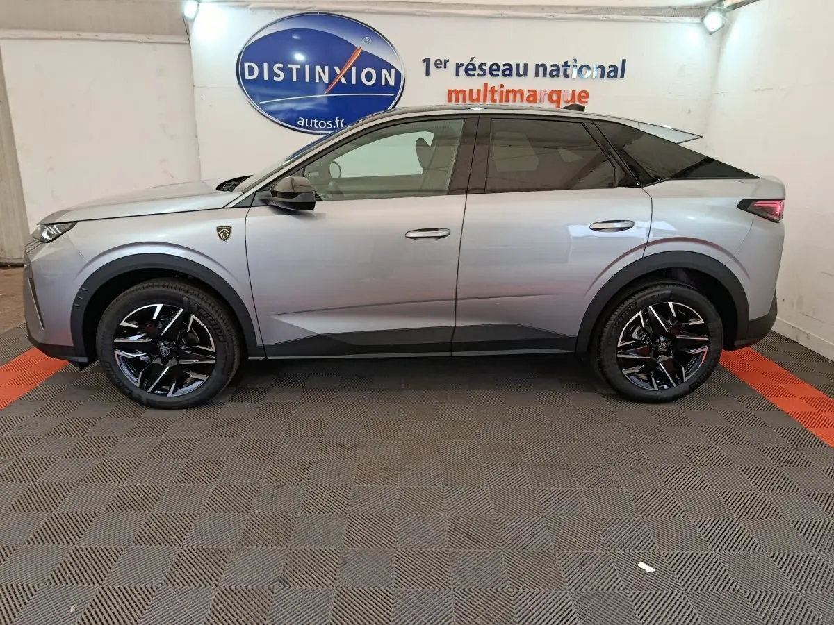 Profil côté gauche du Peugeot 3008 gris clair hybride 2025 avec jantes noires et détails noirs contrastants.