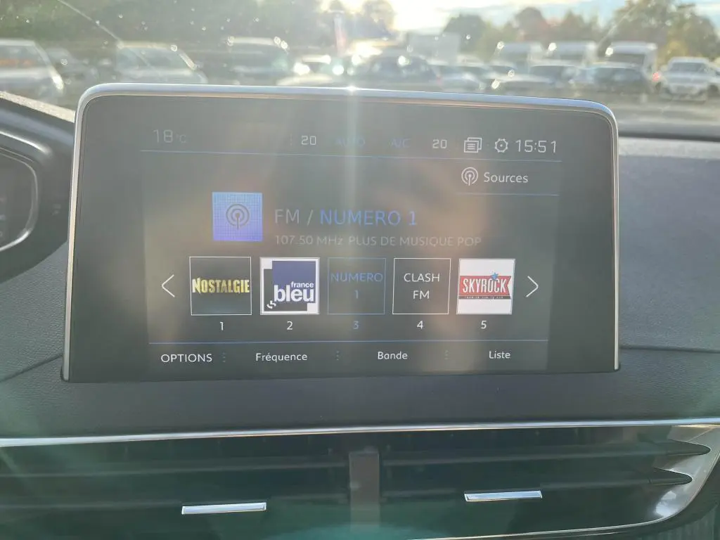 Écran tactile central du Peugeot 3008 2020 affichant les stations radio avec tableau de bord noir et aérateurs chromés.