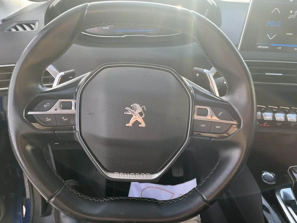 Vue rapprochée du volant compact noir du Peugeot 3008 2020 avec commandes intégrées et logo lion central chrome.