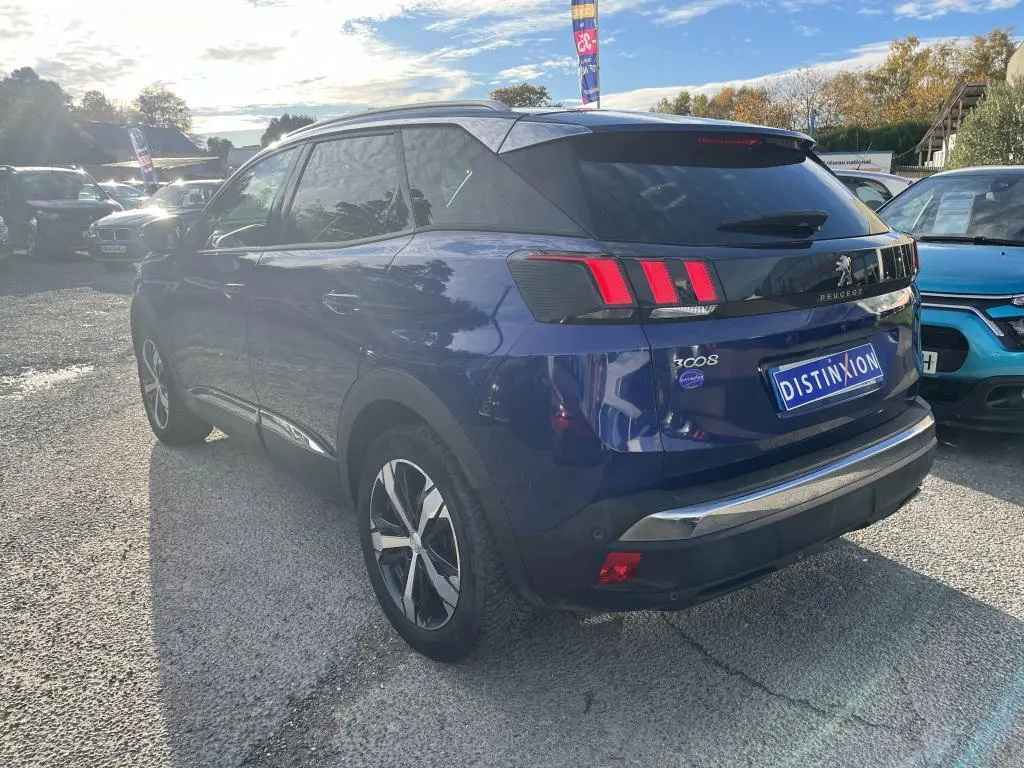 Peugeot 3008 bleu magnétique vue 3/4 arrière droit, avec feux arrière à griffes et vitres surteintées.
