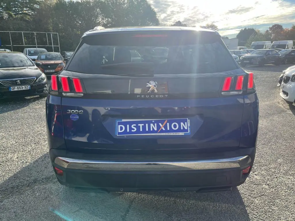 Vue arrière d'un Peugeot 3008 bleu magnétique avec feux arrière à trois griffes et logo lion central.