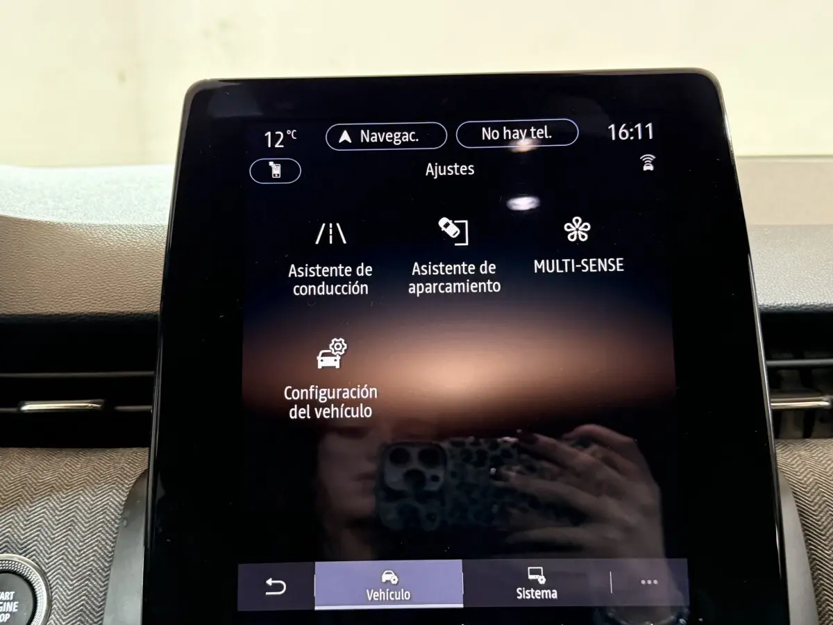 Écran tactile central affichant les réglages du véhicule dans l’habitacle d’une Renault Clio rouge.