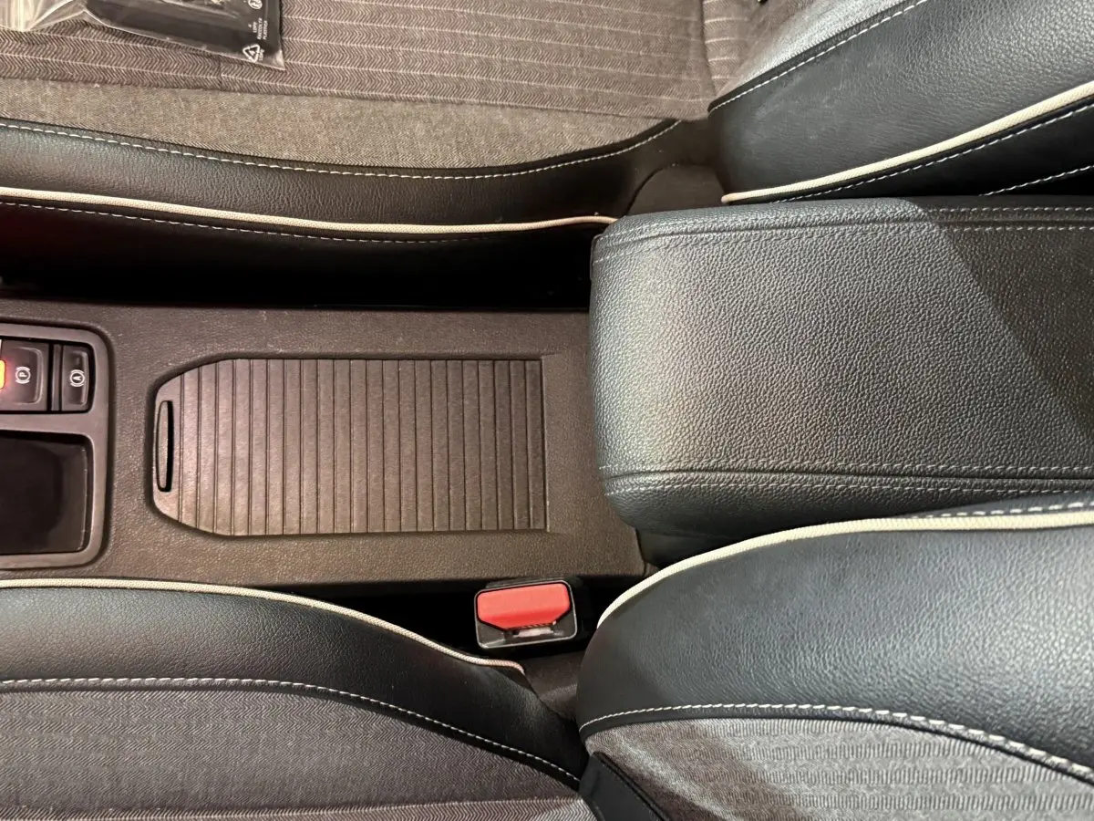 Vue rapprochée de la console centrale et des sièges noirs avec surpiqûres blanches de la Renault Clio Techno TCe 90 2024.