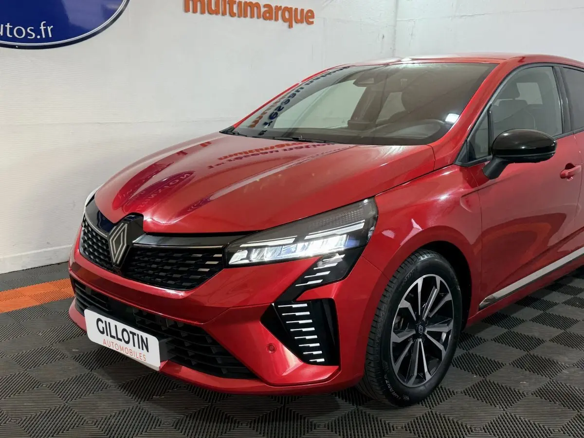 Renault Clio Techno TCe 90 rouge vue 3/4 avant droit, avec phares LED et jantes alliage noires.