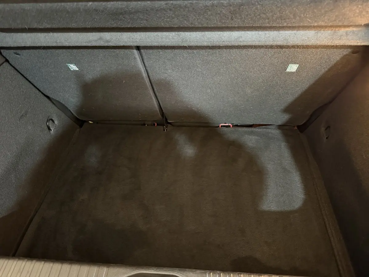 Vue intérieure du coffre spacieux et tapissé en noir de la Renault Clio Techno TCe 90 rouge 2024.