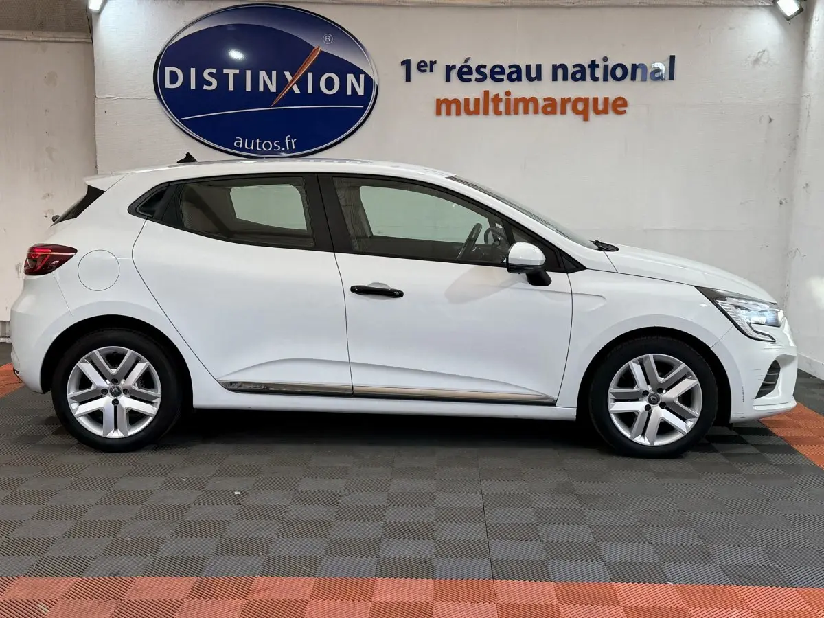Profil droit d'une Renault Clio Business blanche de 2021, avec jantes alliage et poignées noires contrastantes.