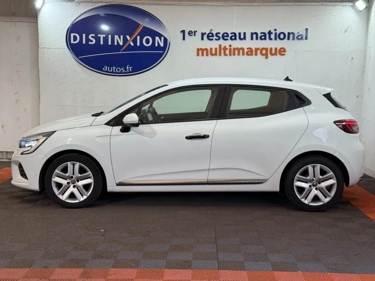 Profil droit d'une Renault Clio blanche Business SCe 65 de 2021, avec jantes alliage et feux arrière LED visibles.