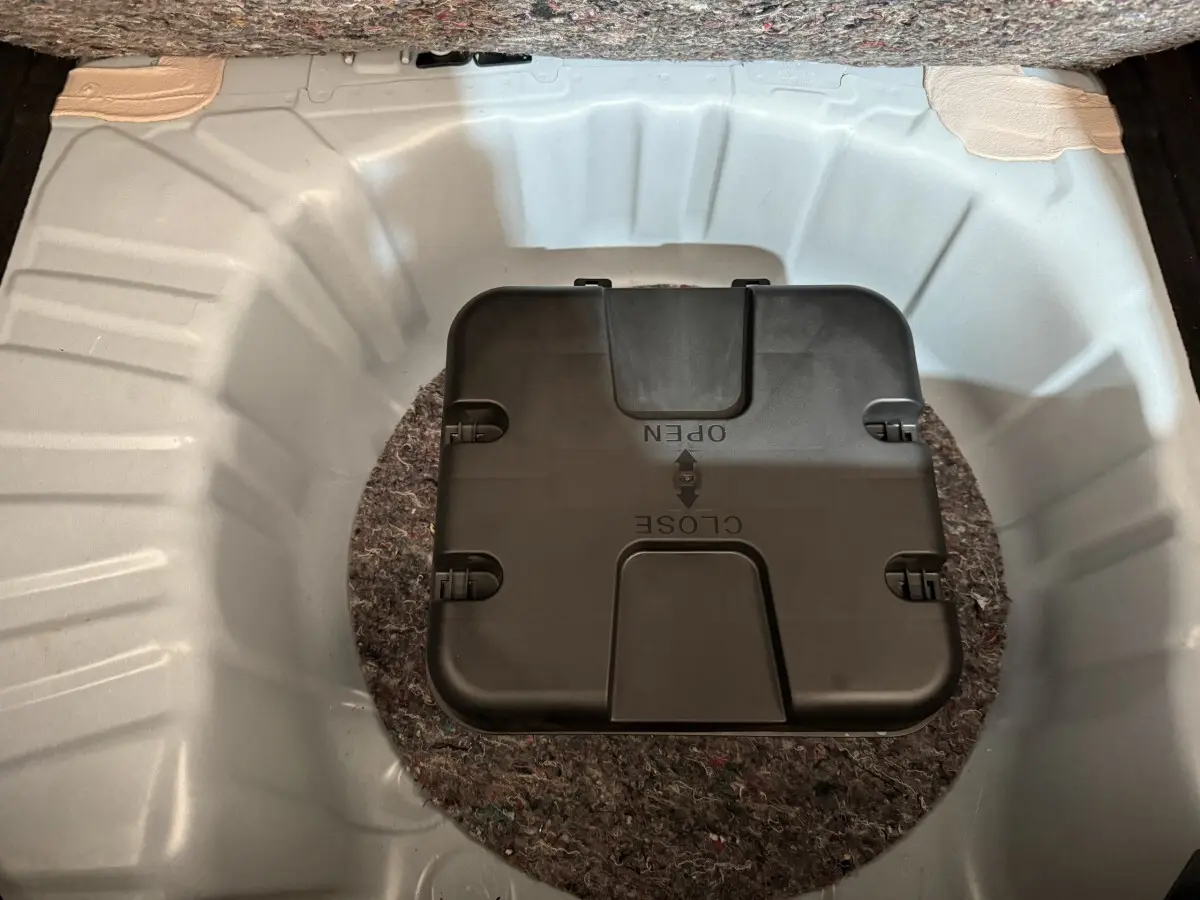 Vue plongeante sur le coffre blanc de la Renault Clio Business avec compartiment noir central marqué open/close.