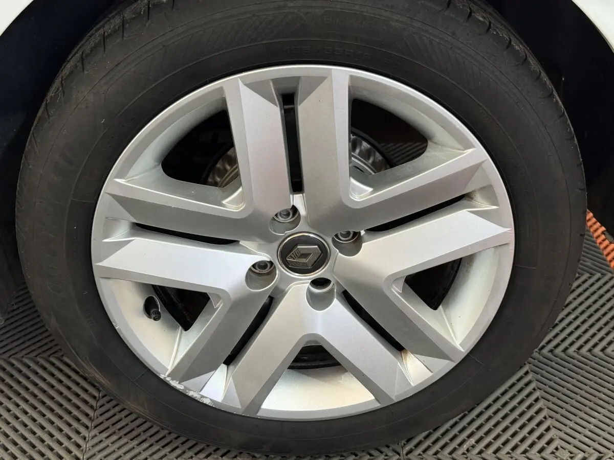 Gros plan sur la roue avant gauche de la Renault Clio Business blanche, avec jante alliage à cinq branches doubles.