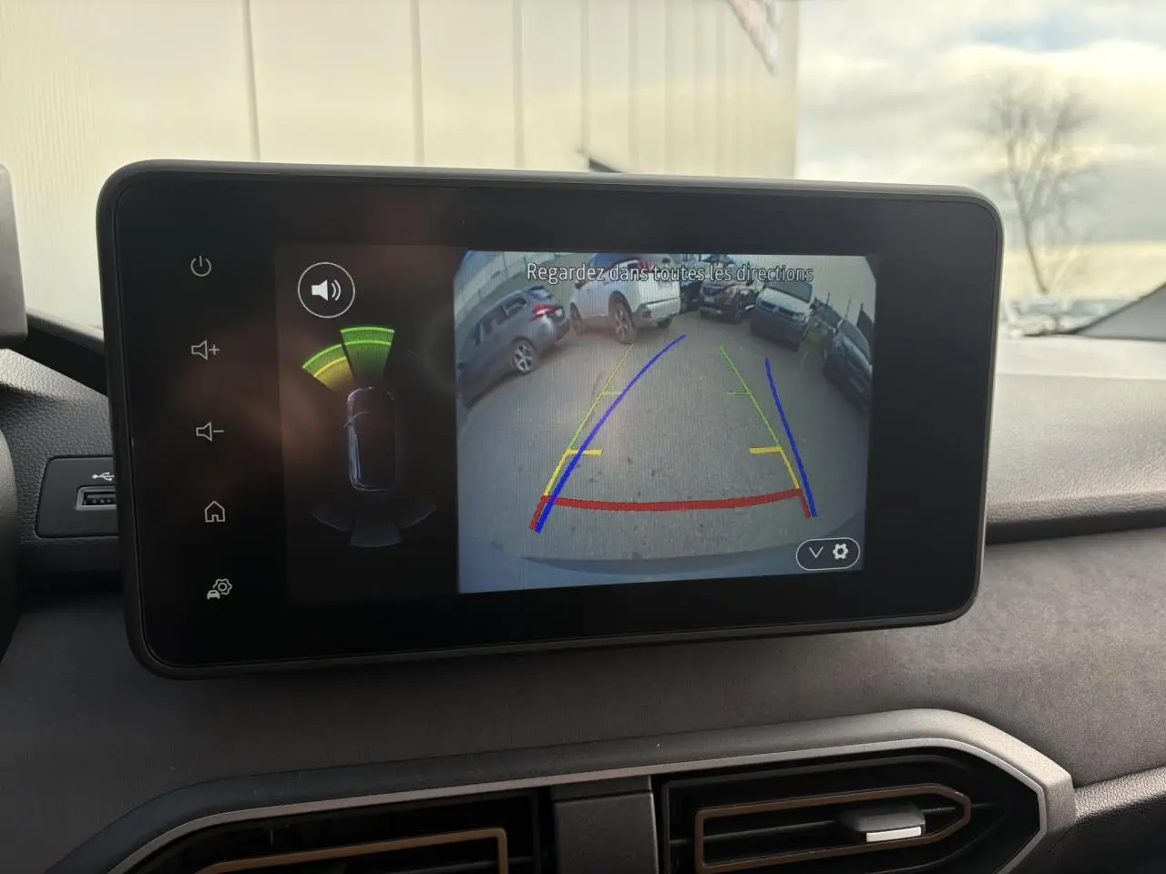 Écran tactile intérieur du Dacia Jogger 2024 montrant la caméra de recul avec guidage coloré et capteurs de proximité.