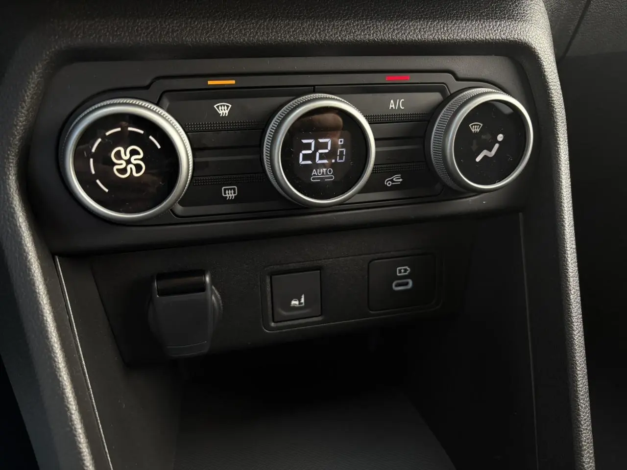 Gros plan sur les commandes de climatisation automatique du tableau de bord du Dacia Jogger Gris Urbain 2024.