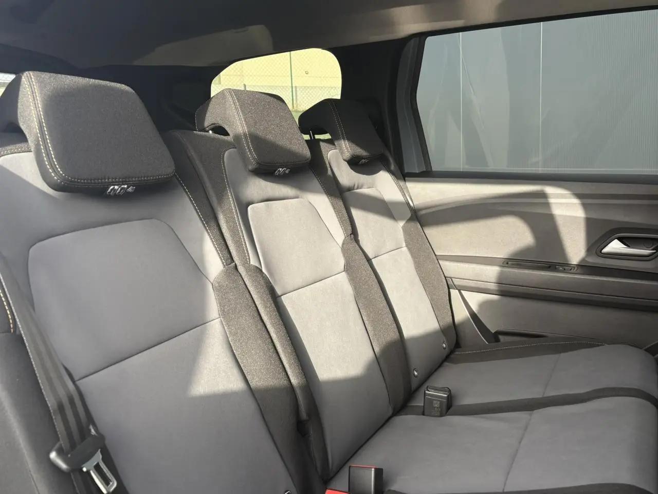 Banquette arrière en tissu gris clair et foncé du Dacia Jogger ECO-G 100 vue côté droit avec appuie-têtes intégrés.