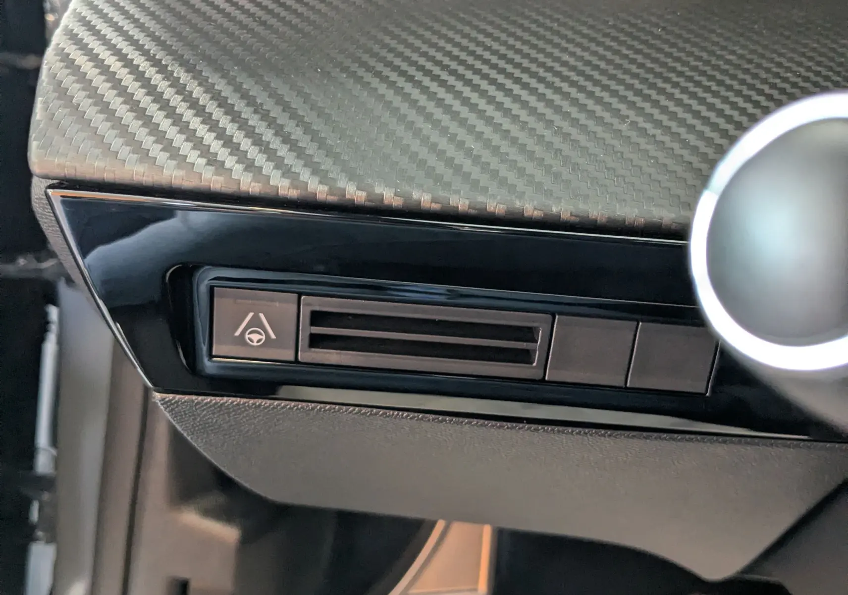 Détail de la console côté conducteur avec finition carbone et pédales aluminium dans un Peugeot 508 SW gris Selenium 2024.