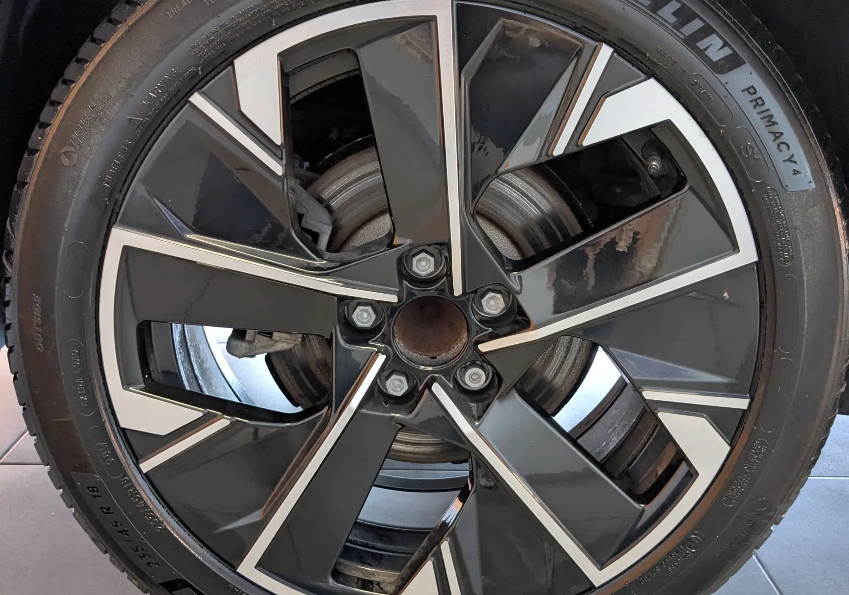 Gros plan sur la jante aluminium 18 pouces bicolore de la Peugeot 508 SW gris selenium de 2024.