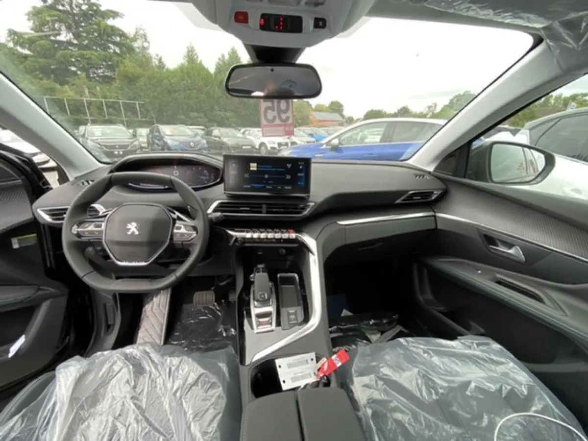 Intérieur avant du Peugeot 3008 2021 noir Perla Nera, tableau de bord moderne avec écran tactile et volant compact.