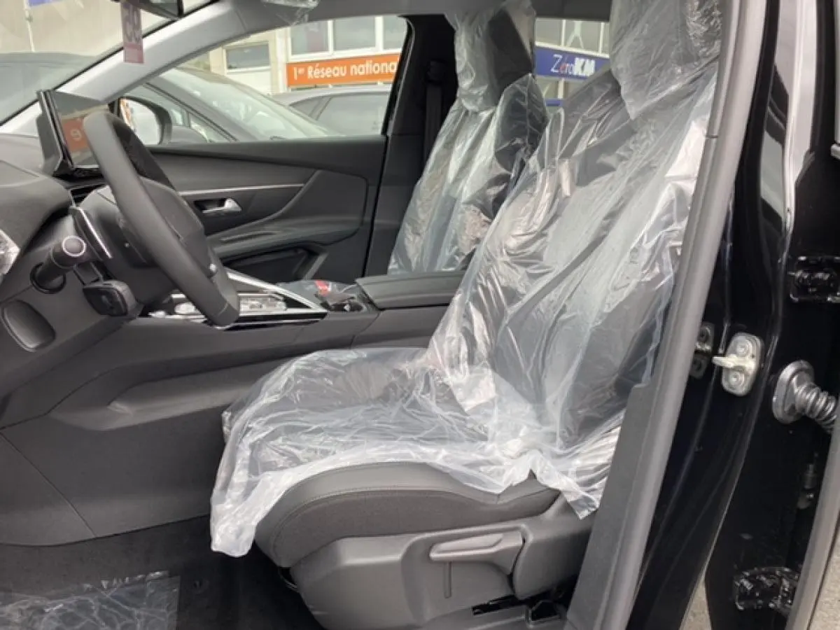Vue intérieure côté conducteur du Peugeot 3008 noir Perla Nera 2021, sièges protégés par housses plastiques.