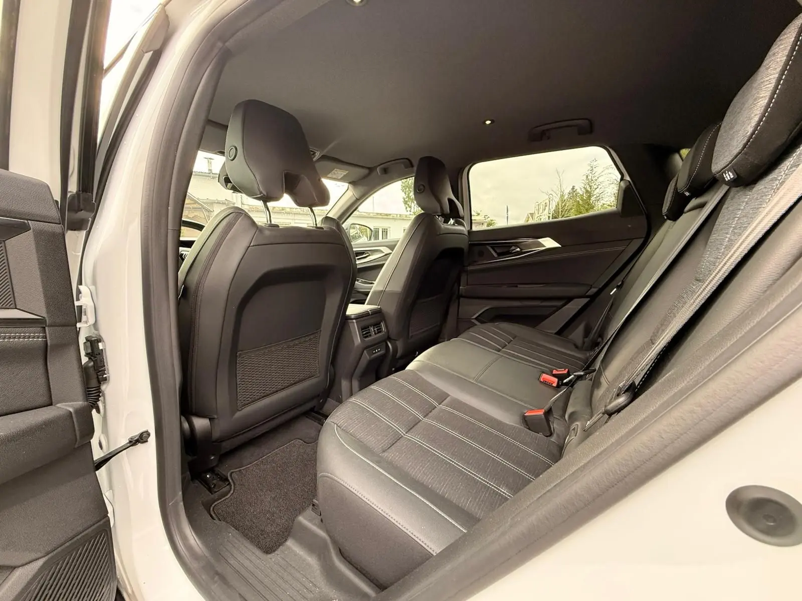 Vue intérieure côté droit sur la banquette arrière en tissu noir du Renault Austral E-Tech 200 blanc nacré avec toit noir.