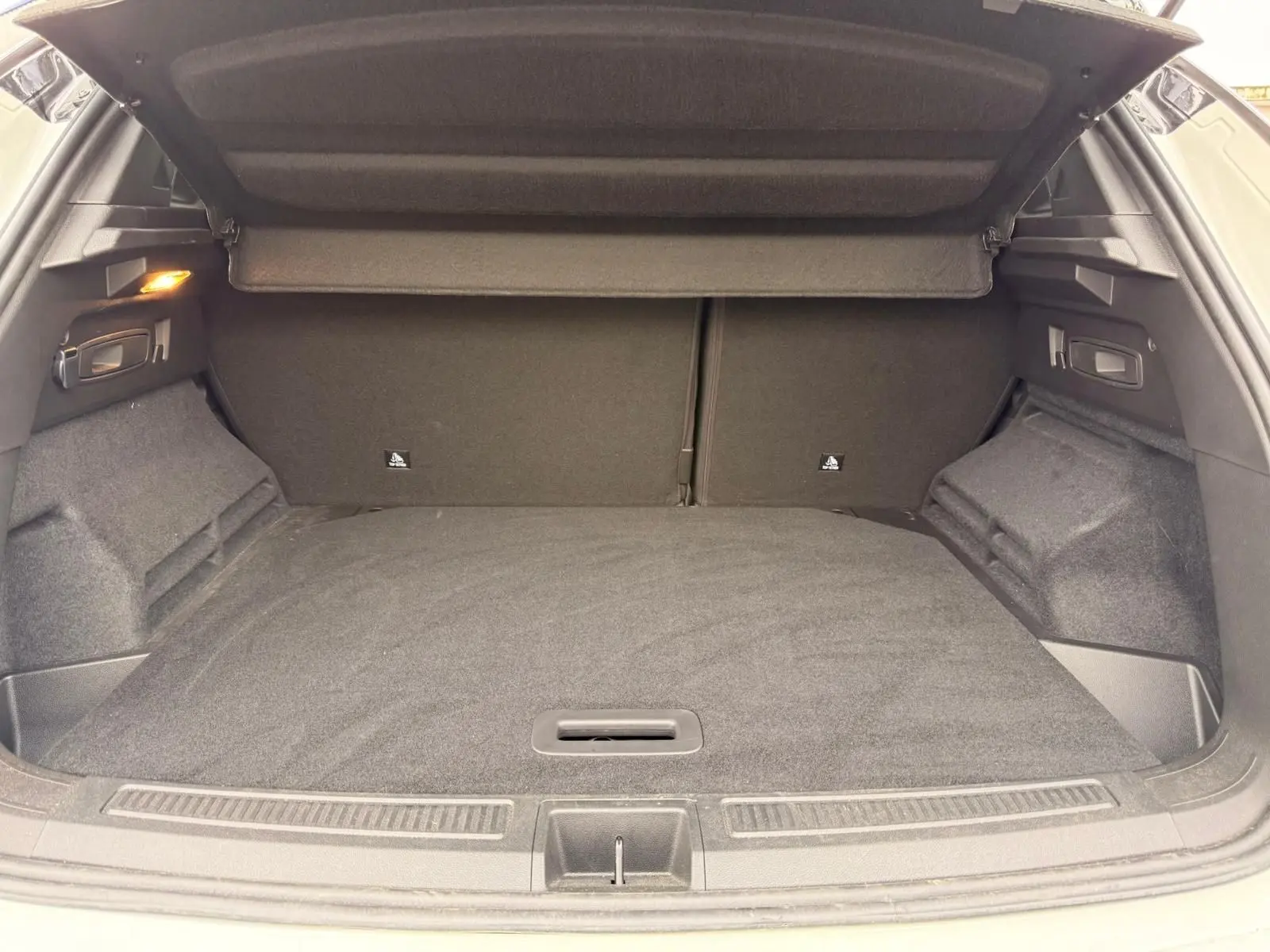 Coffre ouvert du Renault Austral E-Tech 200 blanc nacré, vue intérieure arrière montrant un espace de chargement spacieux et propre.