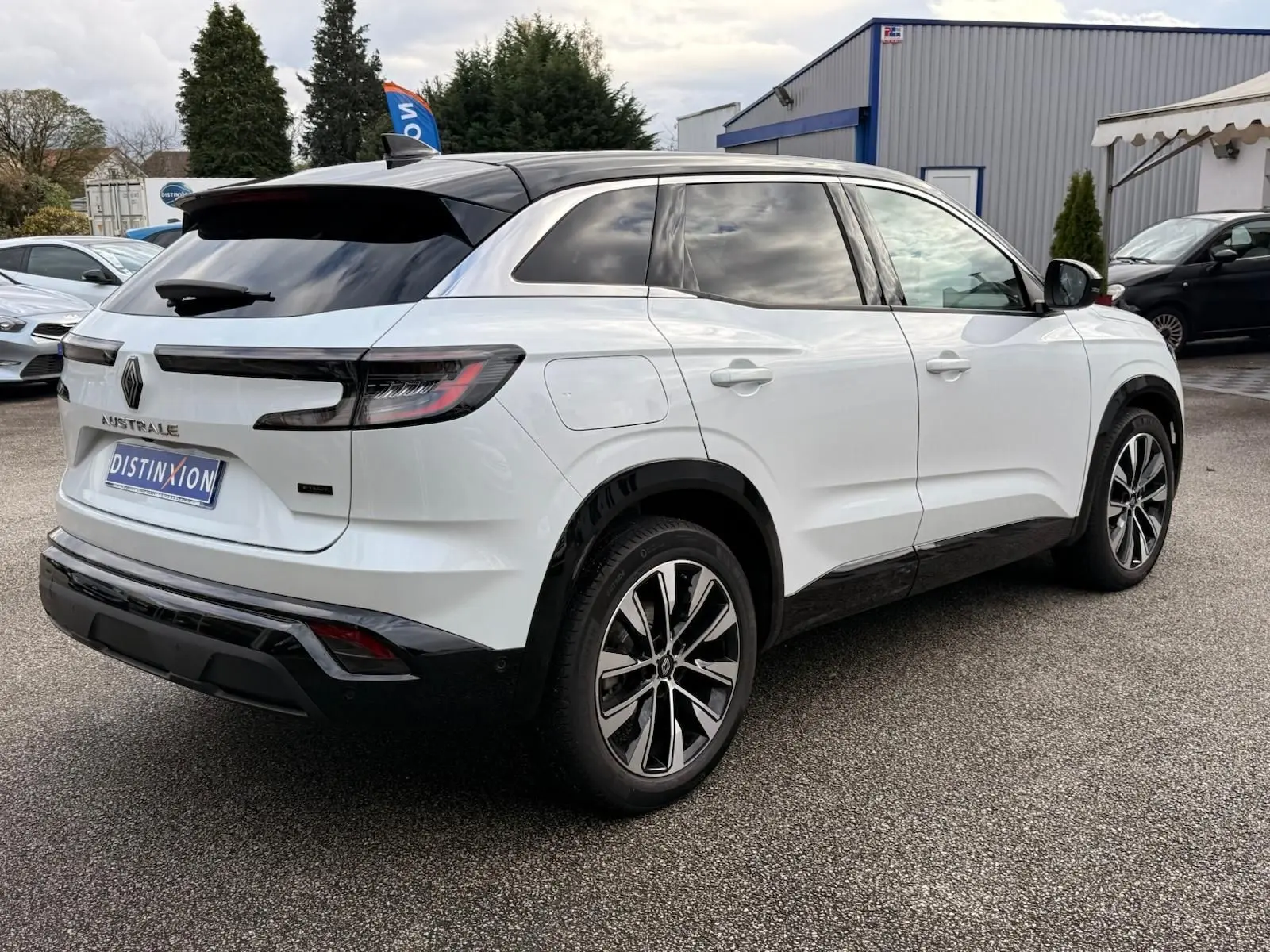 Vue 3/4 arrière droite du Renault Austral blanc nacré avec toit noir, jantes alliage et feux arrière LED distinctifs.