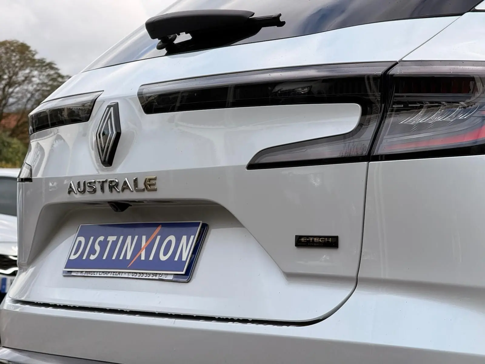 Gros plan arrière droit du Renault Austral blanc nacré avec logo E-TECH et feux arrière noirs soulignés de rouge.
