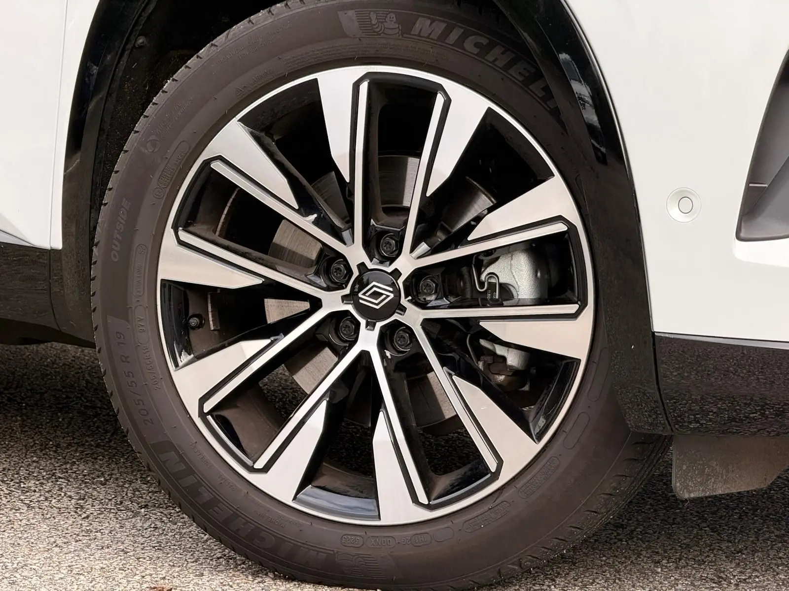 Gros plan sur la jante alliage bicolore du Renault Austral E-Tech 200 blanc nacré avec toit noir.