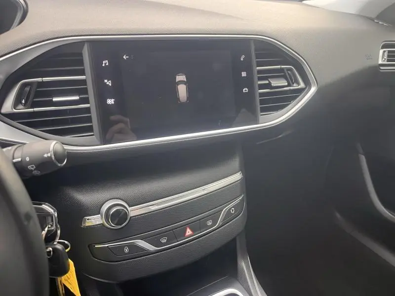 Vue intérieure centrée sur la console centrale et l'écran tactile de la Peugeot 308 1.5 BlueHDi blanc Banquise.