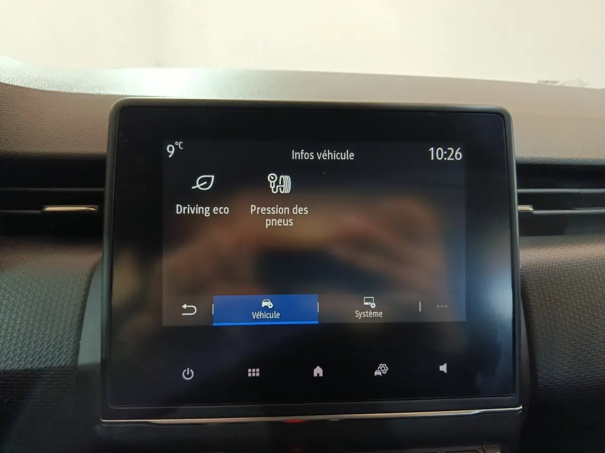 Écran tactile central de la Renault Clio gris clair 2023 affichant les infos véhicule, vue de face rapprochée.