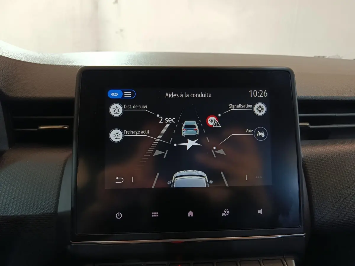Écran tactile central de la Renault Clio 2023 affichant les aides à la conduite avec alertes de distance et voie.