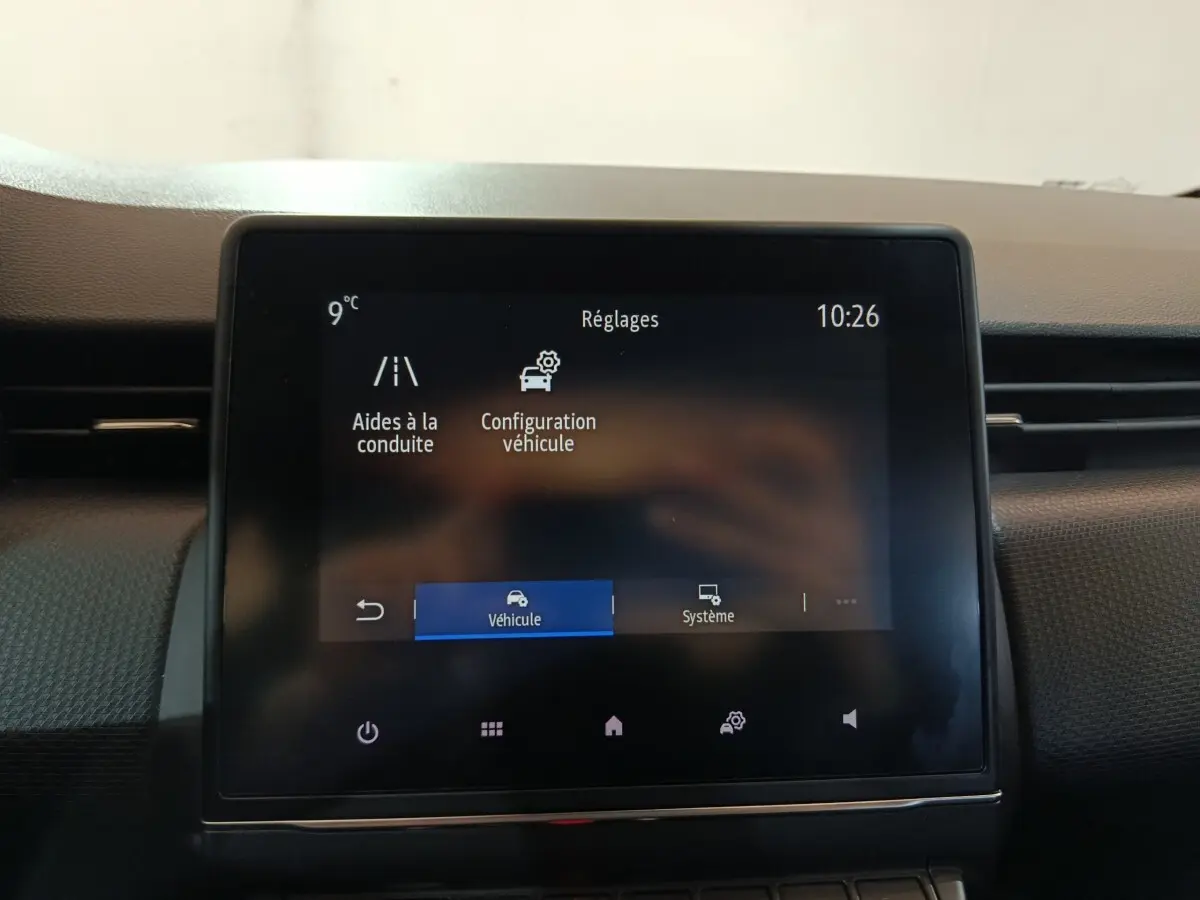 Écran tactile central de la Renault Clio gris clair 2023 affichant le menu réglages aides à la conduite.