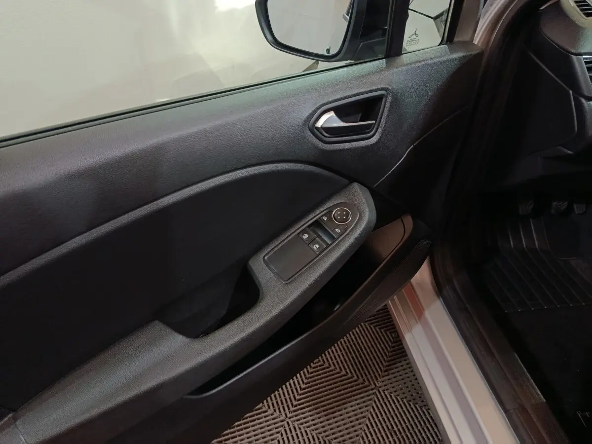 Vue intérieure côté conducteur de la porte noire avec commandes électriques sur Renault Clio gris clair 2023.