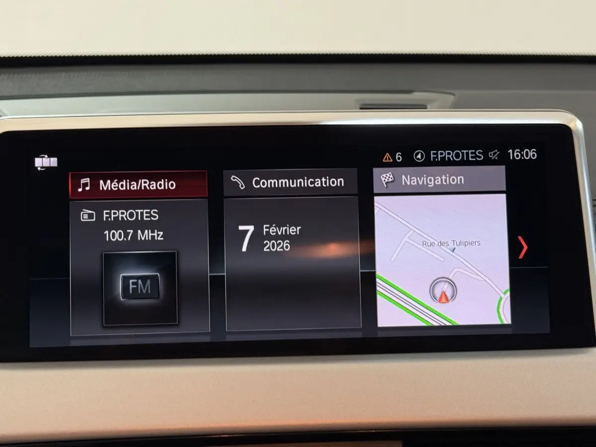 Écran central du tableau de bord du BMW X2 blanc 2023 affichant radio, communication et navigation.