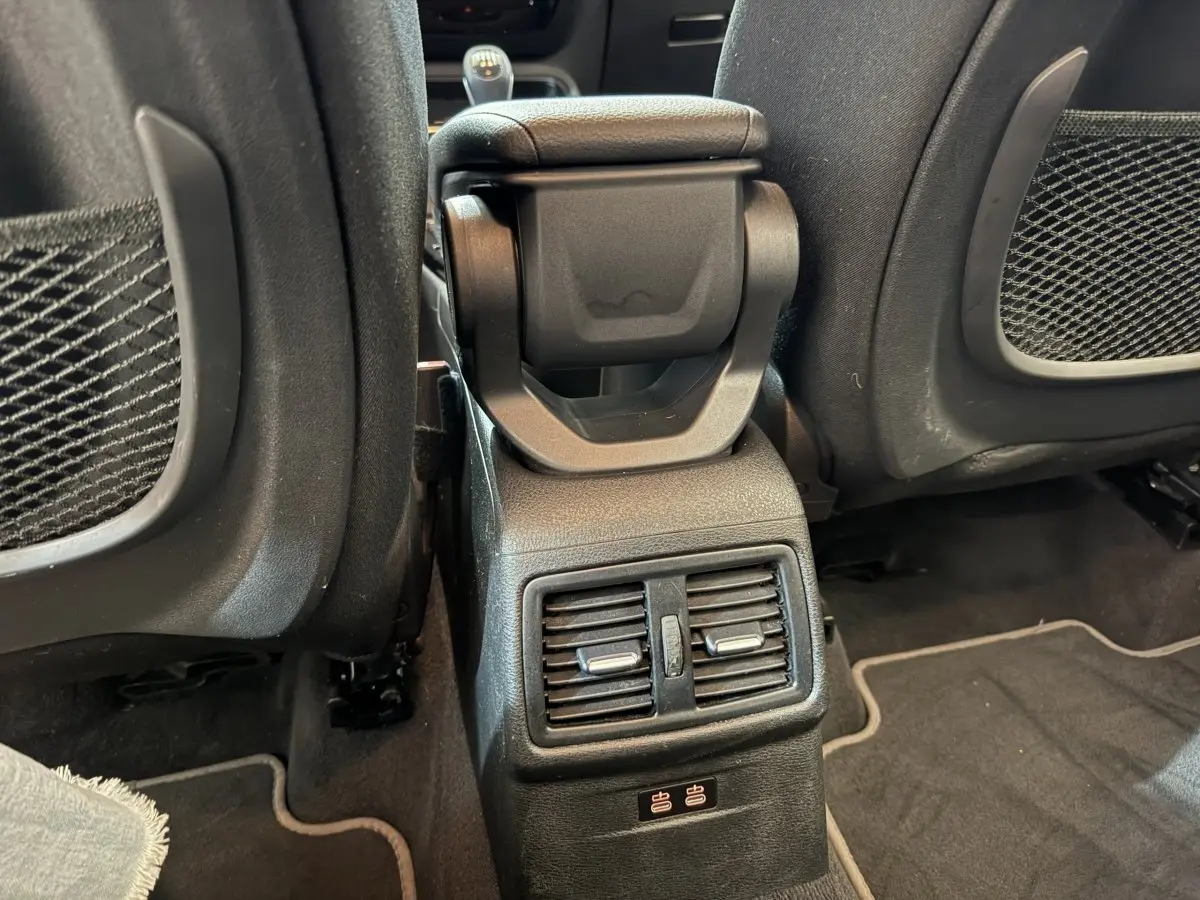 Vue rapprochée de la console centrale arrière noire du BMW X2 sDrive18i Lounge 2023 avec aérateurs et ports USB.