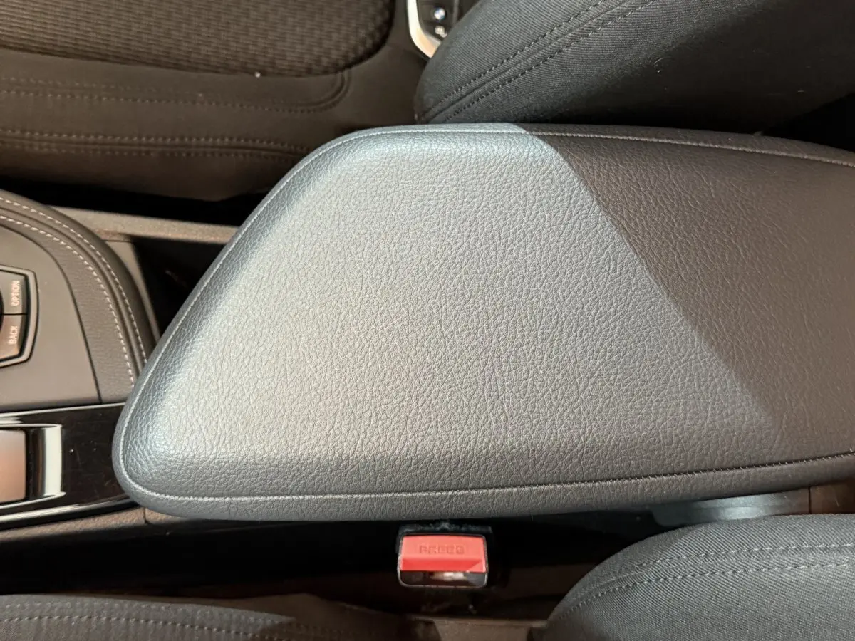 Gros plan sur l'accoudoir central en cuir noir et la molette de sélection du BMW X2 sDrive18i Lounge 2023.