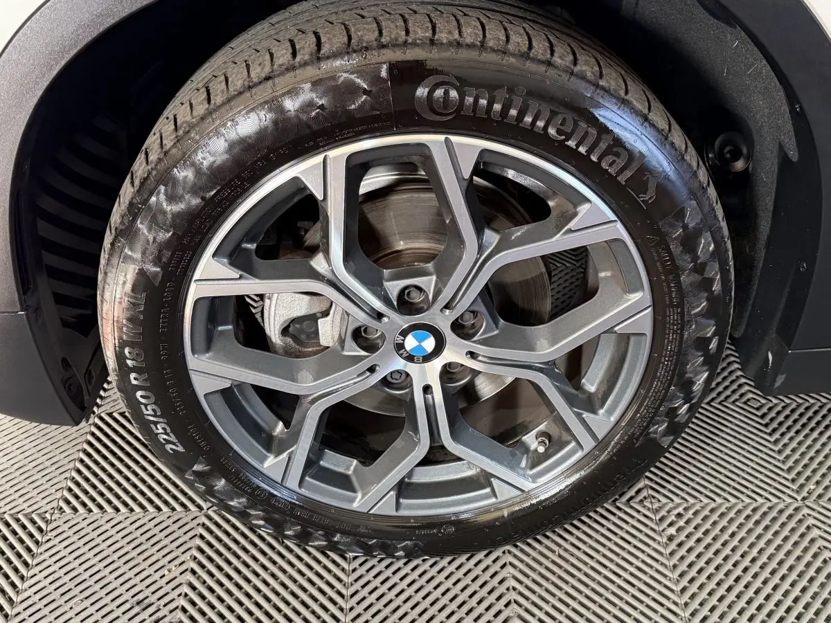 Gros plan sur la jante alliage grise et pneu Continental du BMW X2 sDrive18i Lounge blanc, roue avant droite.