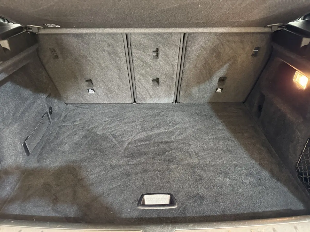 Vue intérieure du coffre spacieux et tapissé de noir du BMW X2 sDrive18i Lounge 2023.