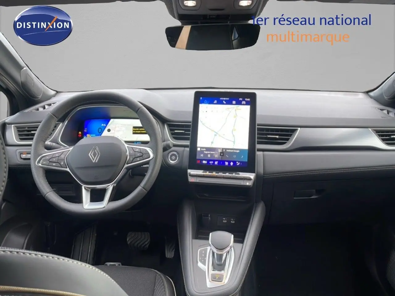 Vue intérieure avant du tableau de bord et volant noir de la Renault Symbioz 2025 avec écran tactile central et levier de vitesses automatique.