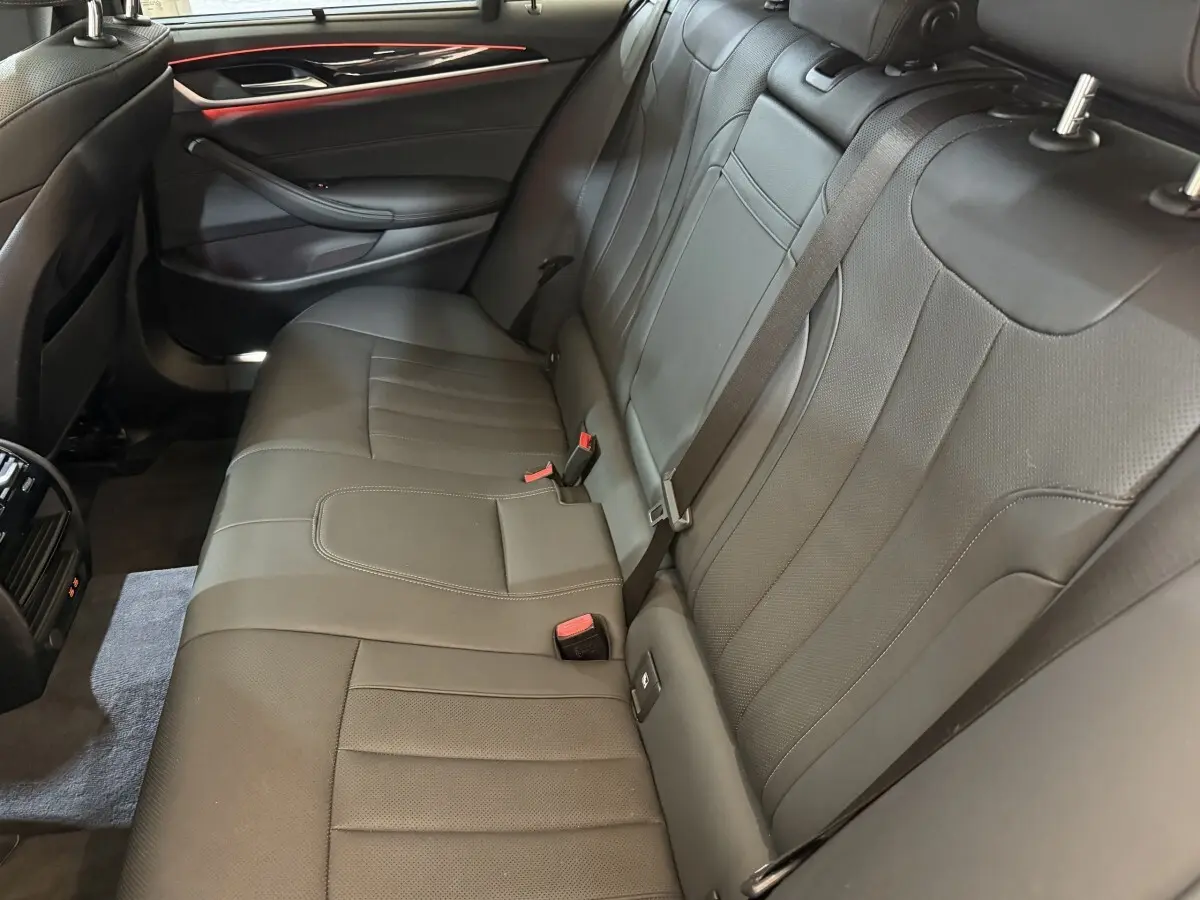 Vue intérieure côté droit de la banquette arrière en cuir noir de la BMW Série 5 Touring 520d M Sport 2023.