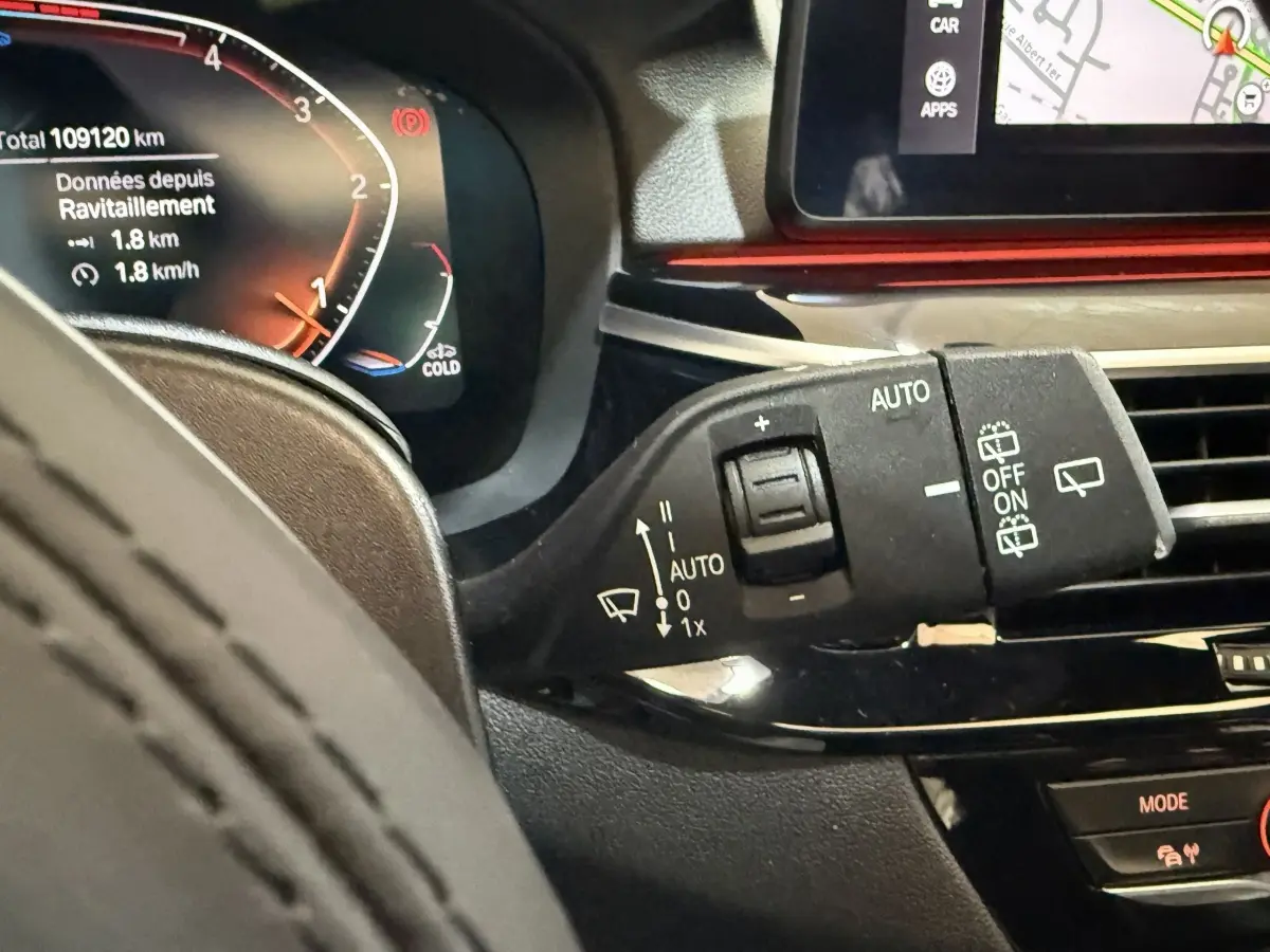 Détail du commodo de commande d’essuie-glace dans l’habitacle noir d’une BMW Série 5 Touring 520d M Sport 2023.