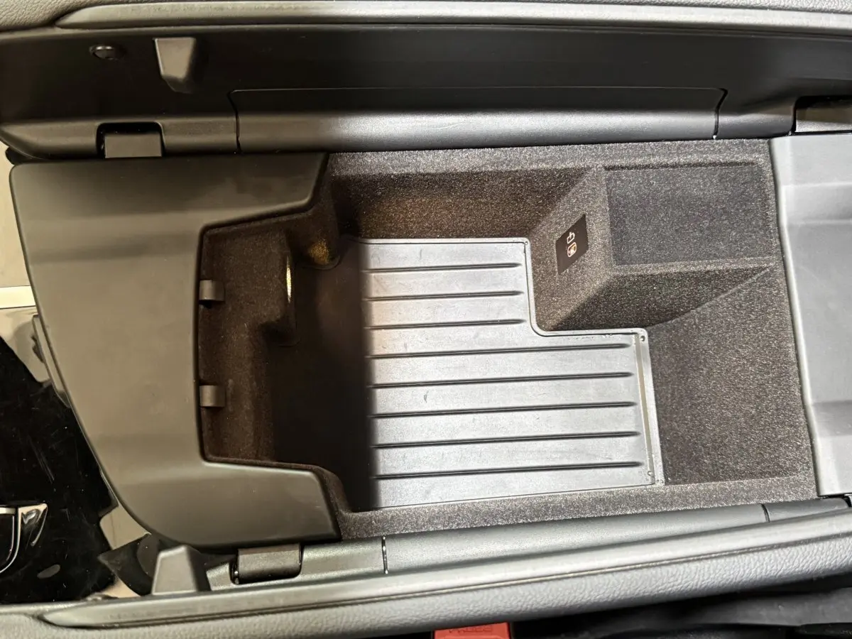 Vue plongeante sur le rangement central intérieur noir de la BMW Série 5 Touring 520d M Sport 2023.