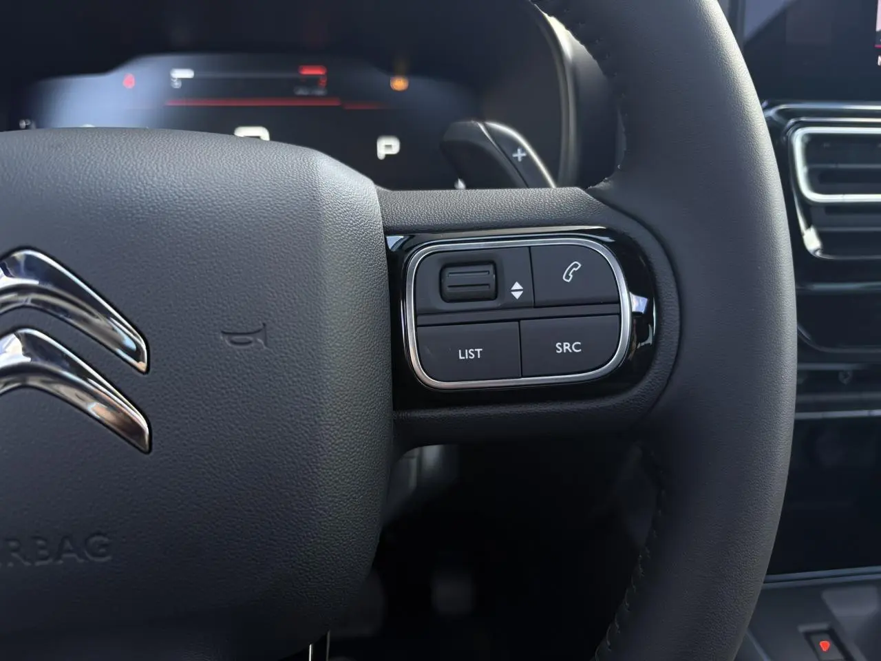 Gros plan sur le volant cuir noir du Citroën C5 Aircross 2026 avec commandes intégrées et logo chromé.