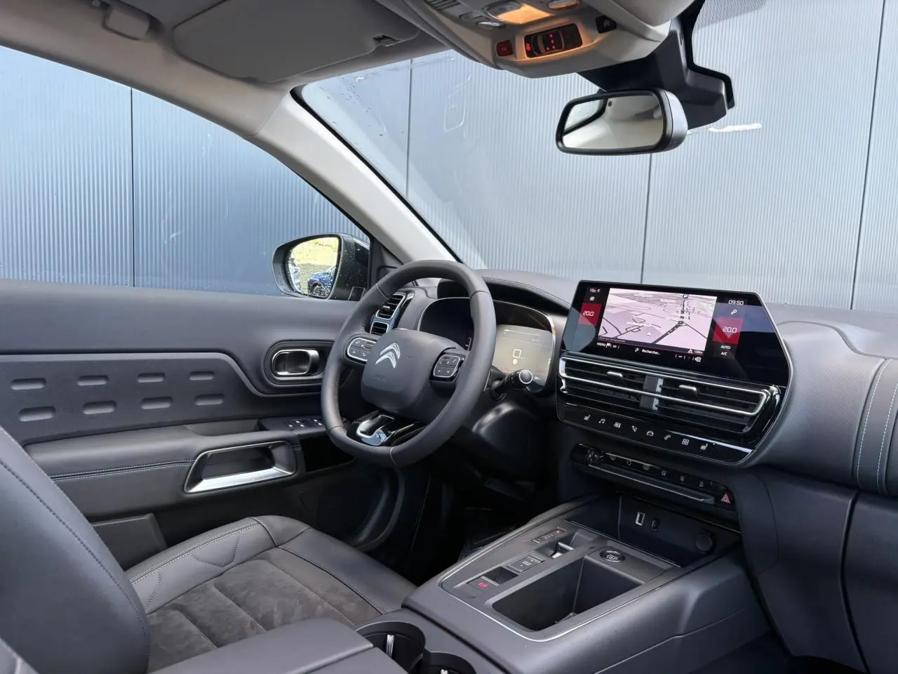 Intérieur du Citroën C5 Aircross gris, vue côté conducteur avec tableau de bord et écran tactile GPS.